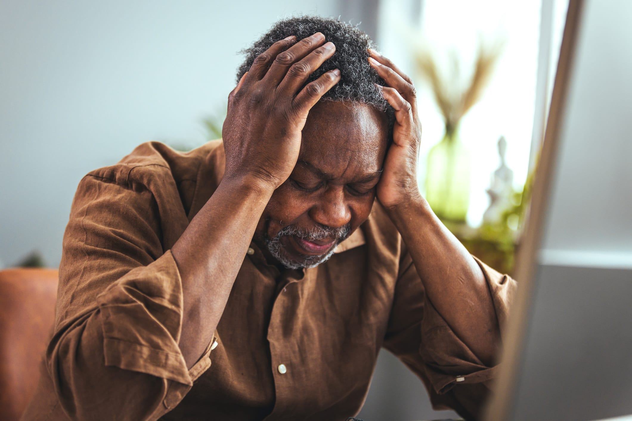 Older man stressed out with hands on face