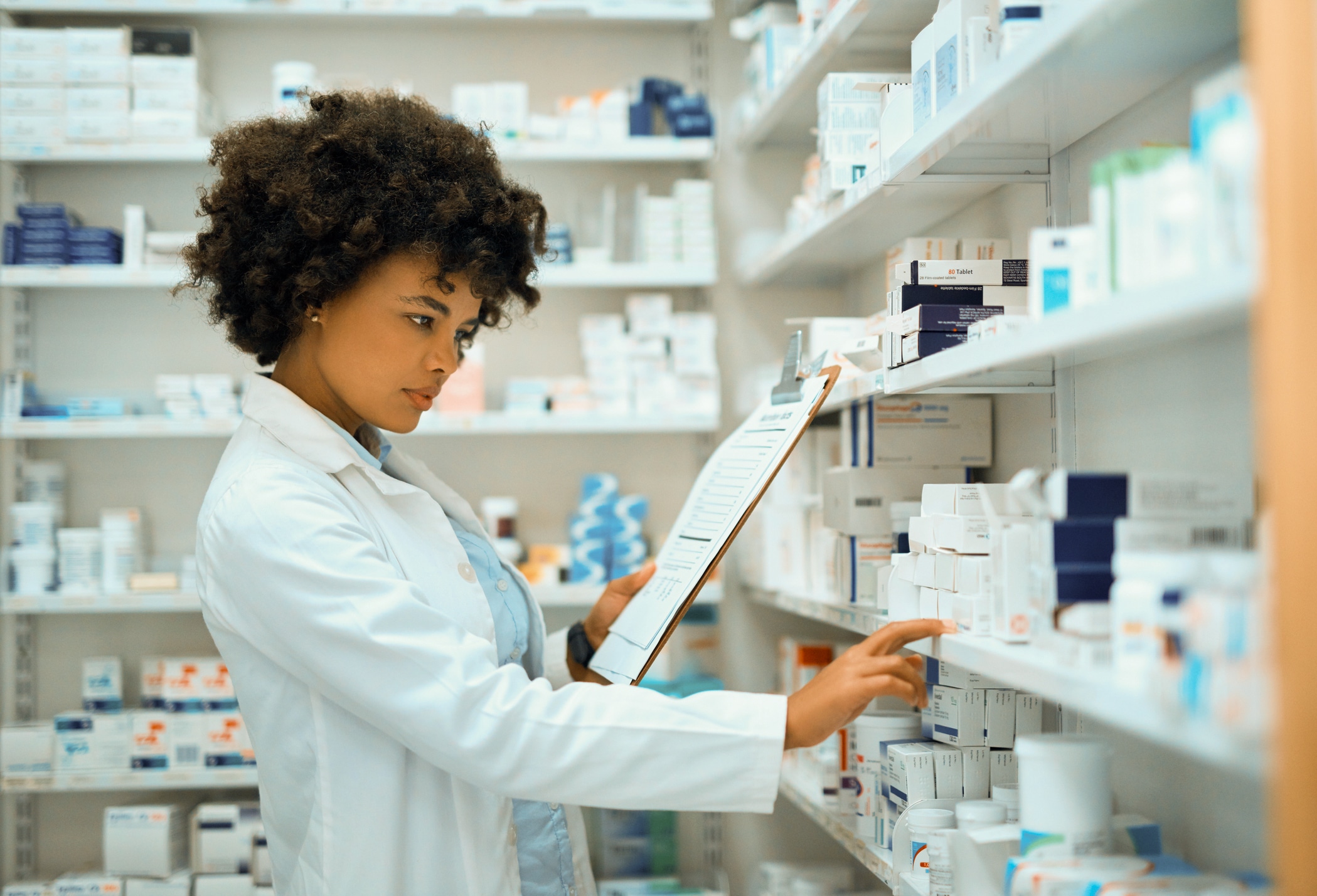 Pharmacist looking at drugs on shelf