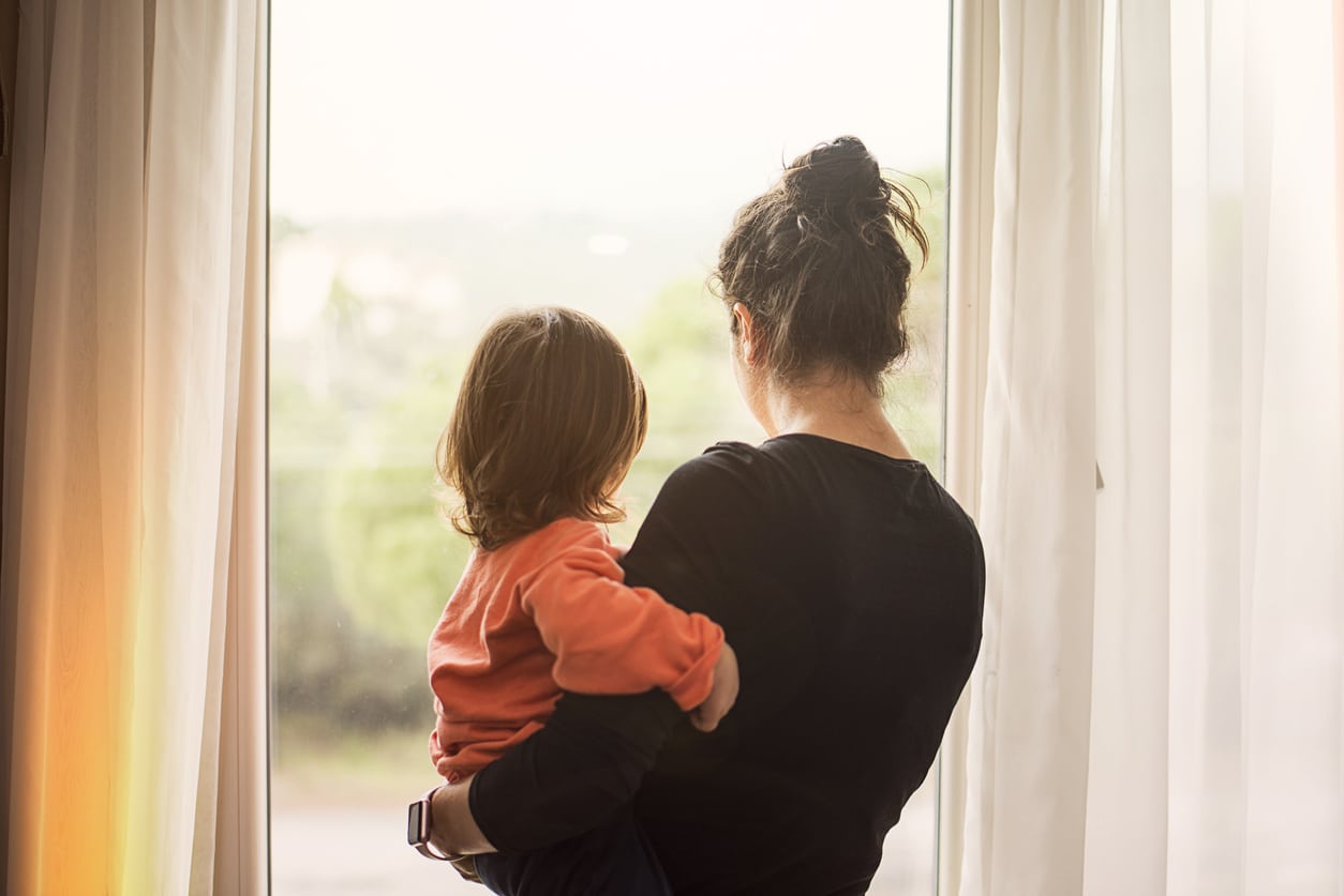 Mother and child looking out window