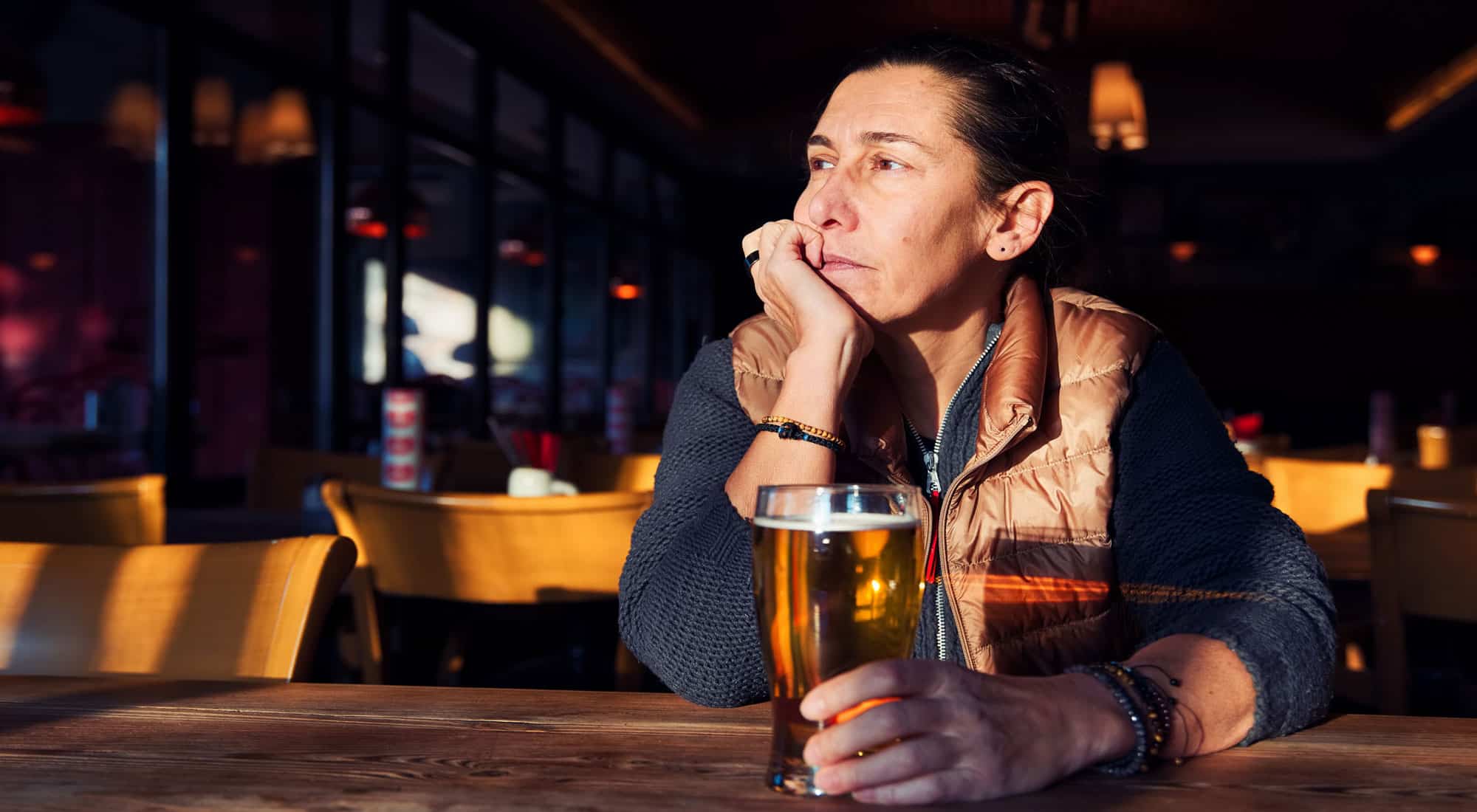 middle-aged woman drinking at bar